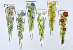 five glass flowers are arranged in the shape of triangulars, each with different colors and sizes