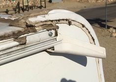 the roof of an old white car that has been gutted and covered with snow