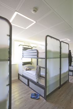 bunk beds are lined up in a room with hard wood flooring and white walls