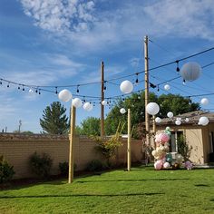 an outdoor party setup with balloons and lights