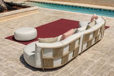 a couch sitting on top of a red rug next to a swimming pool