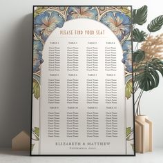 a seating chart with blue flowers on it next to a potted plant and two vases