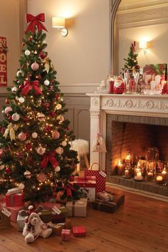 a decorated christmas tree in a living room with presents on the floor and lit candles