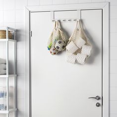 there are two bags hanging on the wall next to each other in front of a door