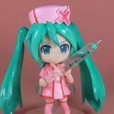 a toy doll holding a knife and wearing a pink dress with long green hair on it's head