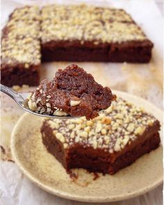 a piece of cake on a plate with a spoon in it and another slice is being lifted from the plate