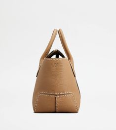 Refined handcrafted stitching characterizes this iconic shopping bag, with tubular handles and Tod's logo stamped on the front. Featuring a removable shoulder strap and an internal pouch, it is crafted in soft calfskin leather. To accompany  your everyday outfits with class and femininity. Designer Medium Satchel With Top Handle, Designer Tan Bag With Handle Drop, Designer Tan Tote Satchel, Designer Tan Bag, Designer Tan Bags With Leather Handles, Luxury Medium Shoulder Bag With Removable Pouch, Designer Tan Satchel With Double Handle, Designer Tan Satchel With Removable Pouch, Luxury Medium Shoulder Bag With Detachable Handle