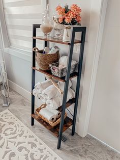 a shelving unit with towels and other items on it in a white walled room