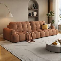 a living room with a couch, coffee table and lamp on the floor in front of a large window