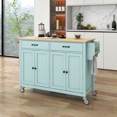 a blue kitchen island with wooden top on wheels