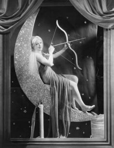 an old photo of a woman sitting on the moon with a bow and arrow in her hand