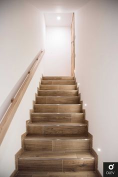 the stairs are made of wood and have white walls