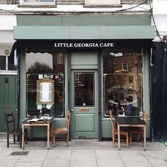 the outside of a little georgia cafe with two tables and chairs in front of it