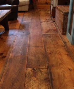 a wood floor in a living room with couches and coffee table next to it