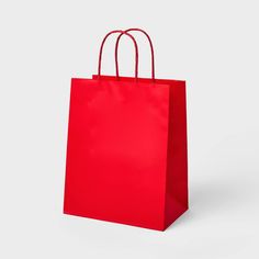 a red shopping bag with handles on a white background, it looks like an empty shopping bag