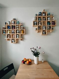 a wooden table topped with a bowl of fruit next to a vase filled with flowers