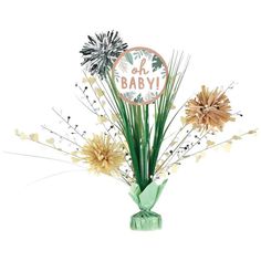 a green vase filled with flowers sitting on top of a table next to a sign that says oh baby