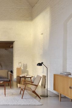 a living room filled with furniture next to a white rug on top of a hard wood floor