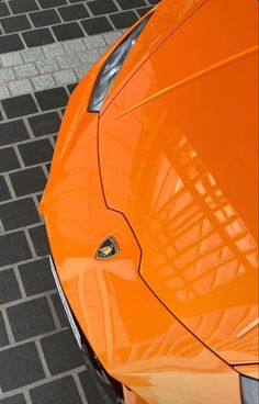 an orange sports car is parked on the street