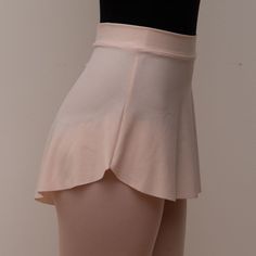 a woman's skirt is shown in front of a white wall