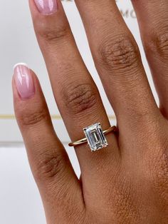 ✥ Elevate your love story to timeless elegance and ethical consciousness with our exquisite 1.79-carat emerald-cut F-color, VS-clarity lab-grown diamond engagement ring in a classic solitaire style. This ring is more than just a symbol of commitment; it's a testament to your dedication to a sustainable future. The emerald-cut diamond, renowned for its captivating elegance and distinctive step-cut facets, takes center stage, radiating with a mesmerizing sparkle and exceptional clarity that mirror the depth of your connection. The solitaire setting adds an understated sophistication, allowing the diamond's natural beauty to shine without distraction. Crafted with meticulous precision and a strong commitment to eco-conscious practices, this ring transcends mere jewelry; it's a representation Emerald Cut Small Engagement Ring, Emerald Lab Grown Engagement Ring, Emerald Engagement Ring Yellow Gold, Engagement Rings Emerald Cut Gold, White Gold Emerald Cut Engagement Ring, 2 Carat Emerald Engagement Rings, Emerald Cut Gold Band, Emerald Engagement Ring Stack, Emerald Cut Engagement Ring With Band