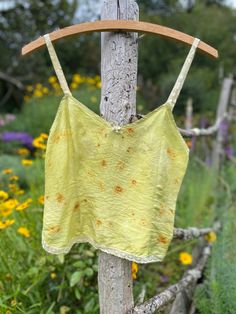 a yellow top hanging on a wooden pole