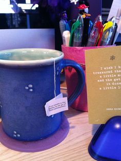 a blue coffee cup with a note attached to it