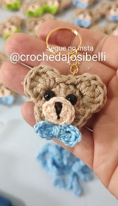 a small crocheted teddy bear keychain in the palm of someone's hand