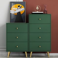 a green chest of drawers sitting next to a painting on top of a wooden dresser