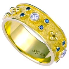 S.Georgios designer 18 Karat Solid Yellow Gold Band Ring all handmade with Byzantine granulation workmanship and a unique velvet background. The stunning ring has 4 brilliant cuts of White Diamonds with a total weight of 0.34 Carats and 16 brilliant-cut Blue Diamonds total weight of 0,22 Carats. This gorgeous piece can be also ordered in all White or Rose Gold, please contact us. The beautiful ring is outstanding in the quality of workmanship and stone collection and is made in our workshop in A Velvet Background, Blue Diamonds, Diamond Band Ring, Gold Ring Sets, Gold Band Ring, Stone Collection, Diamond Rings Bands, White Gold Band, Natural Blue Sapphire