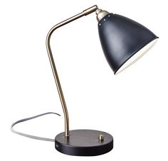 A modern twist on a classic style, the Chelsea desk lamp captures the best of mid-century and industrial task lamps in a clean shape for today. The adjustable matte black metal shade and base are complemented by a black and white fabric cord and antique brass angled arm. An on/off brass push button switch is located on the base. This lamp is smart outlet compatible. Bulb is not included. Adesso Chelsea 21-in Painted Brass/Black Desk Lamp with Metal Shade | 3463-01 Dorm Lighting, Black Desk Lamp, Black And White Fabric, Task Lamps, Black Desk, Desk Light, Desk Lamps, Mid Century Modern Design, Decor Lighting