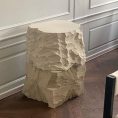 a large rock sitting on top of a hard wood floor next to a white wall