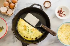 an omelet is being cooked in a skillet with cheese and other ingredients