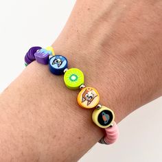 A must-have for any Bluey fan, this comfortable and waterproof bracelet is fun and easy to wear. With polymer beads referencing summer fun, the kiwi rug, and "Sleepytime", you'll have all of your favorite Bluey and Bingo moments with you.  Bracelet is 7 inches long with a 1.5 inch  extension chain. Width: 10 mm (at widest point). Consists of polymer clay beads plus one glass heart bead, all stainless steel findings and spacer beads, and quartz crystal chip beads on the end of the extension chain.  Please message me if you need a bracelet longer than 8.5 inches or shorter than 7! Playful Green Plastic Bracelets, Colorful Adjustable Playful Friendship Bracelets, Playful Polymer Clay Bracelet As Gift, Playful Polymer Clay Bracelet For Gift, Colorful Fun Friendship Bracelets, Playful Multicolor Letter Beads Friendship Bracelets, Cute Adjustable Polymer Clay Bracelets, Adjustable Cute Polymer Clay Bracelets, Playful Plastic Jewelry For The Beach