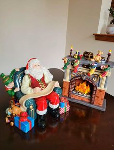 a santa clause figurine sitting on top of a table next to a fireplace