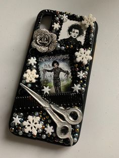 a cell phone case decorated with snowflakes and pictures, scissors and beading