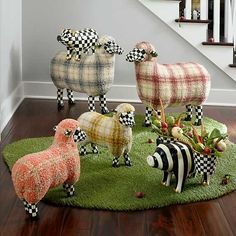 three sheep and two zebras are standing on the grass in front of a stair case