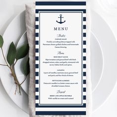 a menu card with an anchor on it next to a white plate and green leaves