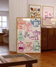 a kitchen area with a table, refrigerator and pictures on the wall in front of it