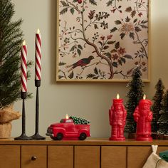 a christmas scene with candles and ornaments on a dresser