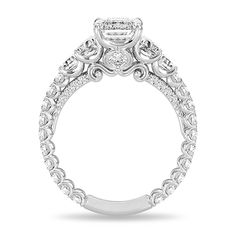 a white gold engagement ring with an intricate design and round diamonds on the band, set in