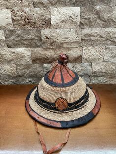 Vintage adult size African Fulani hat or use as a wall hanging. I was at an estate sale and the couple had lived in Mali for years and moved back to Denver with all they  collected in Africa and decorated their basement, this is where I picked up this Fulani hat. All natural products , woven with leather application , this one has a chin strap.  The very top leather notch is leaning, other than that it is I perfect condition.  Solid weaving and stitching. The outside measures 14 inches. The inside where the head would fit measures 9 inches. As always if over on shipping I do refund shipping charges. Vintage Handmade Costume Hats And Headpieces, Vintage Brown Handmade Hat Bands, Vintage Handmade Brown Hat Bands, Handmade Vintage Hat Bands, Vintage Brown Cap Costume Hat, Handmade Vintage Cap Style Hat, Vintage Handmade Cap Hat, Handmade Vintage Cap Hats, Vintage Handmade Natural Color Hats