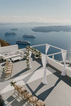 an outdoor wedding setup on the roof of a building with water in the back ground