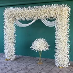 a wedding arch decorated with white flowers