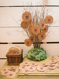 a table topped with lots of paper cut out hearts and tree branches on top of it