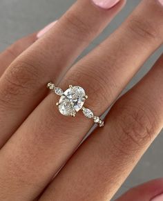 a woman's hand with a diamond ring on top of her finger and the bottom half