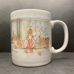 a white coffee mug with two mice on the outside and one mouse in the inside