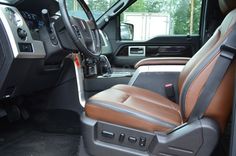 the interior of a truck with brown leather seats