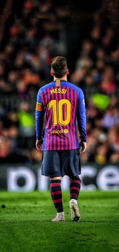 a man standing on top of a soccer field wearing a blue and red shirt with the number 10 on it