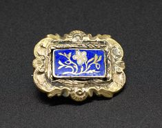 Step back in time with this beautiful Victorian mourning brooch.  Featuring a blue enamel finish and a delicate floral motif, this rectangular silver-colored brooch is a stunning piece of history.  Dating back to the 19th century and made in England, this brooch is not only a statement piece, but a piece of heritage.  Add a touch of sophistication to any outfit with this exquisite piece.  Condition: Good Condition. Enamel plate was possibly glued on (repair), but not visible Dimensions: 35x20mm (approx) Packaging: Our branded suedette Catantica pouch.   Dear buyers, please note that most of our items are pre-owned and might have some signs of wear, the degree of which will be reflected in the description. We always try our best to describe all imperfections. Please look over your desired i Antique Jewelry Victorian, Enamel Plate, Enamel Brooch, Vintage Box, Gold Tone Necklace, Antique Art Deco, Art Deco Jewelry, Silver Blue, Antique Victorian